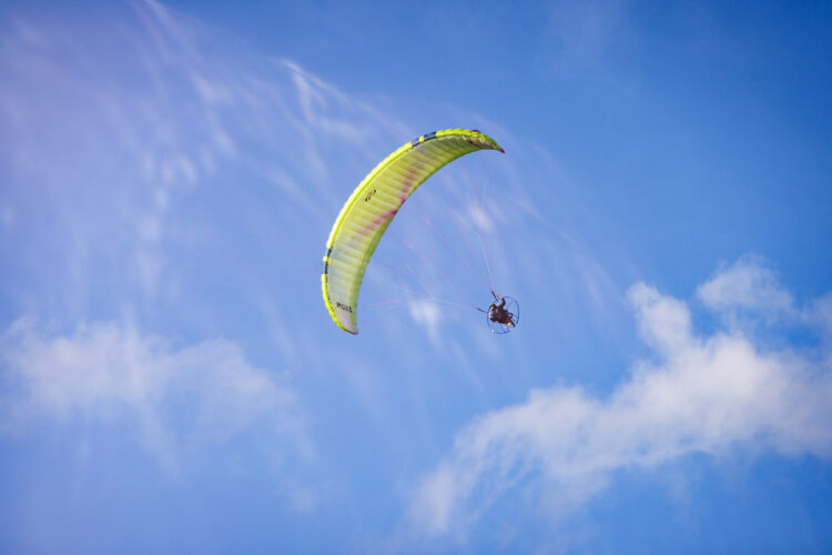 Paramotor flying under a colourful wing